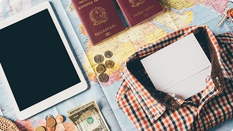 iPad, money, and passport on top of world map
