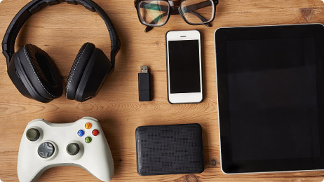 Game controller, headphones, iPad and cellphone on tabletop